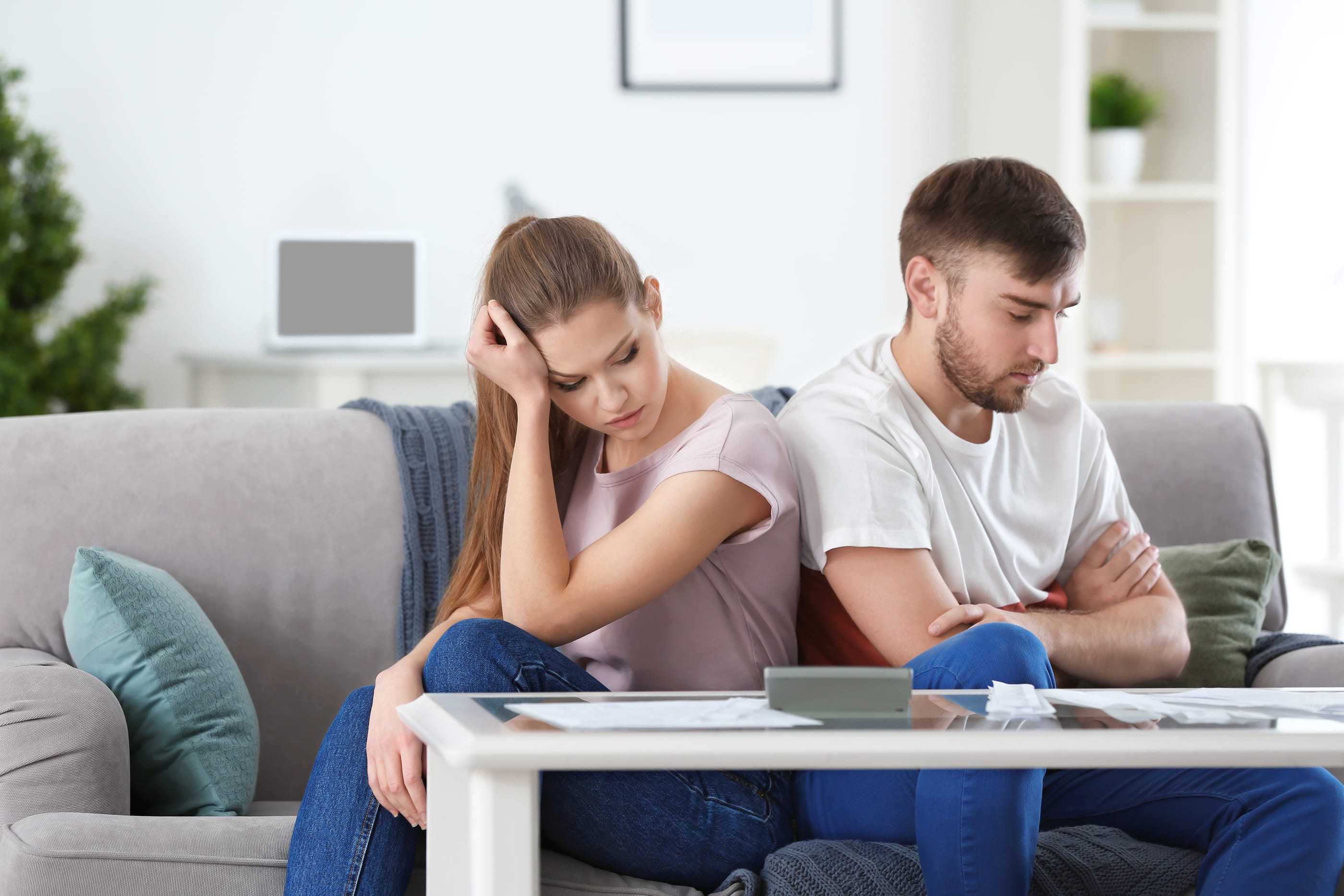 Unhappy couple near table with bills at home. Money problems in relationship