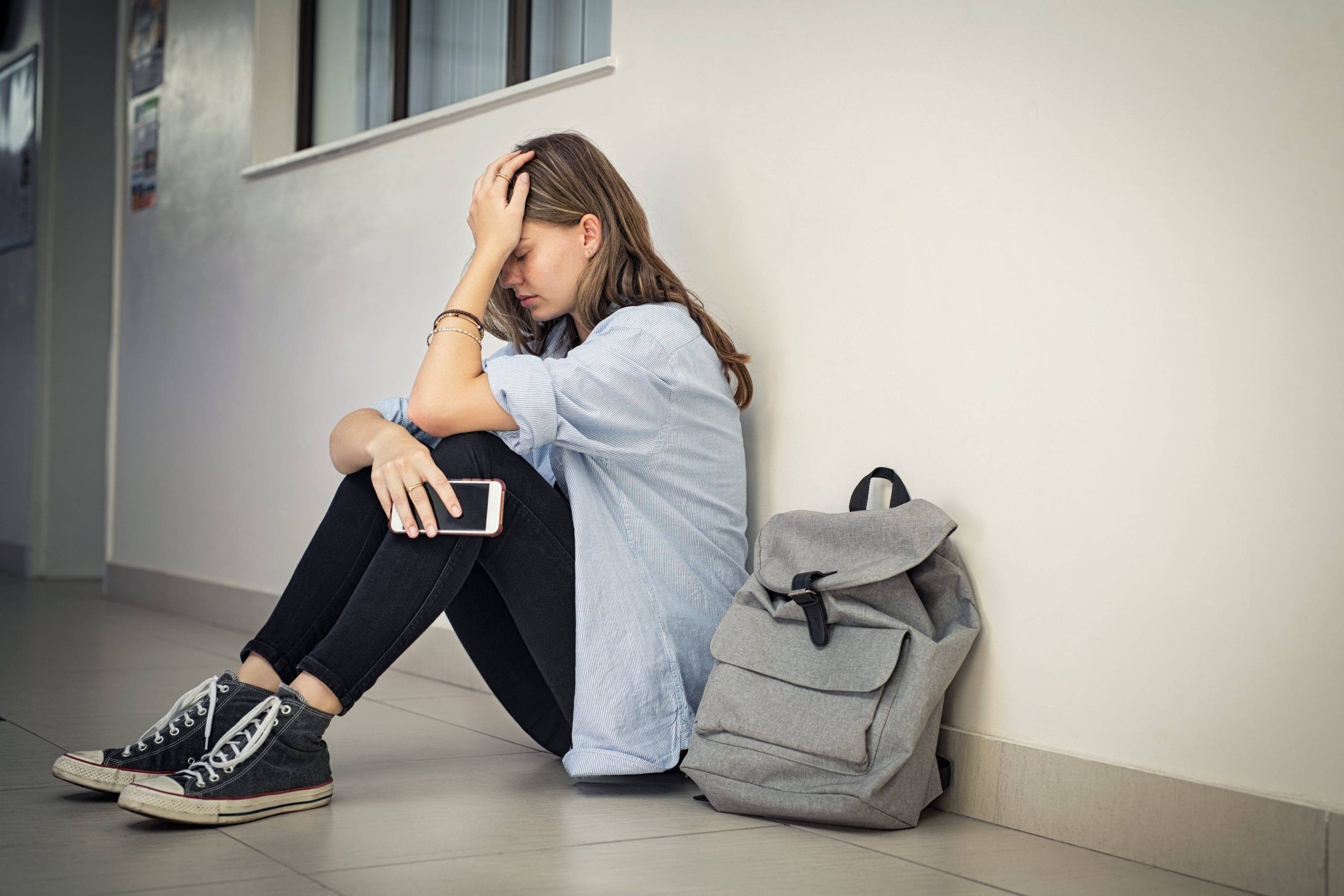 upset girl sitting in hallway